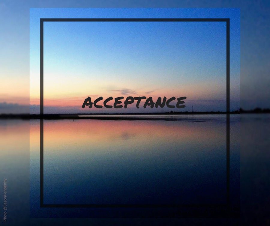 The world "acceptance" superimposed over an image of the setting sun over a lake