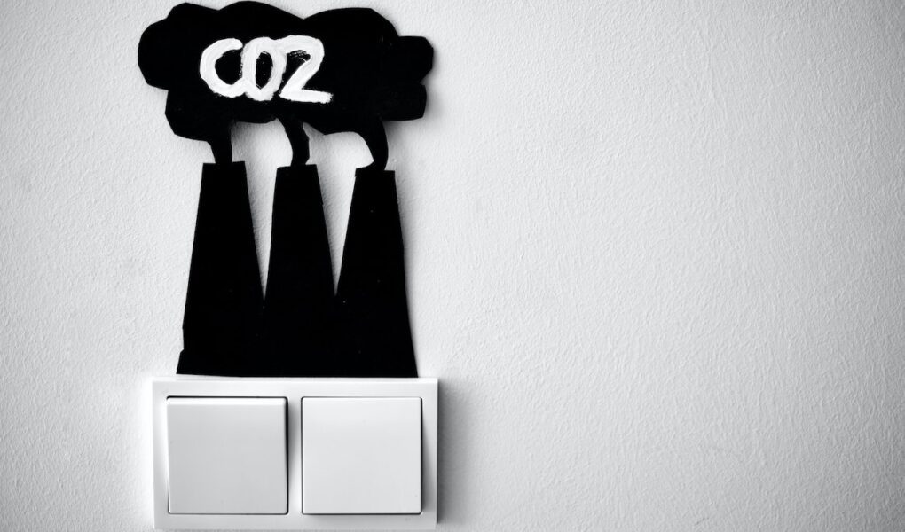 A graphic representation of carbon emissions coming from a wall light switch