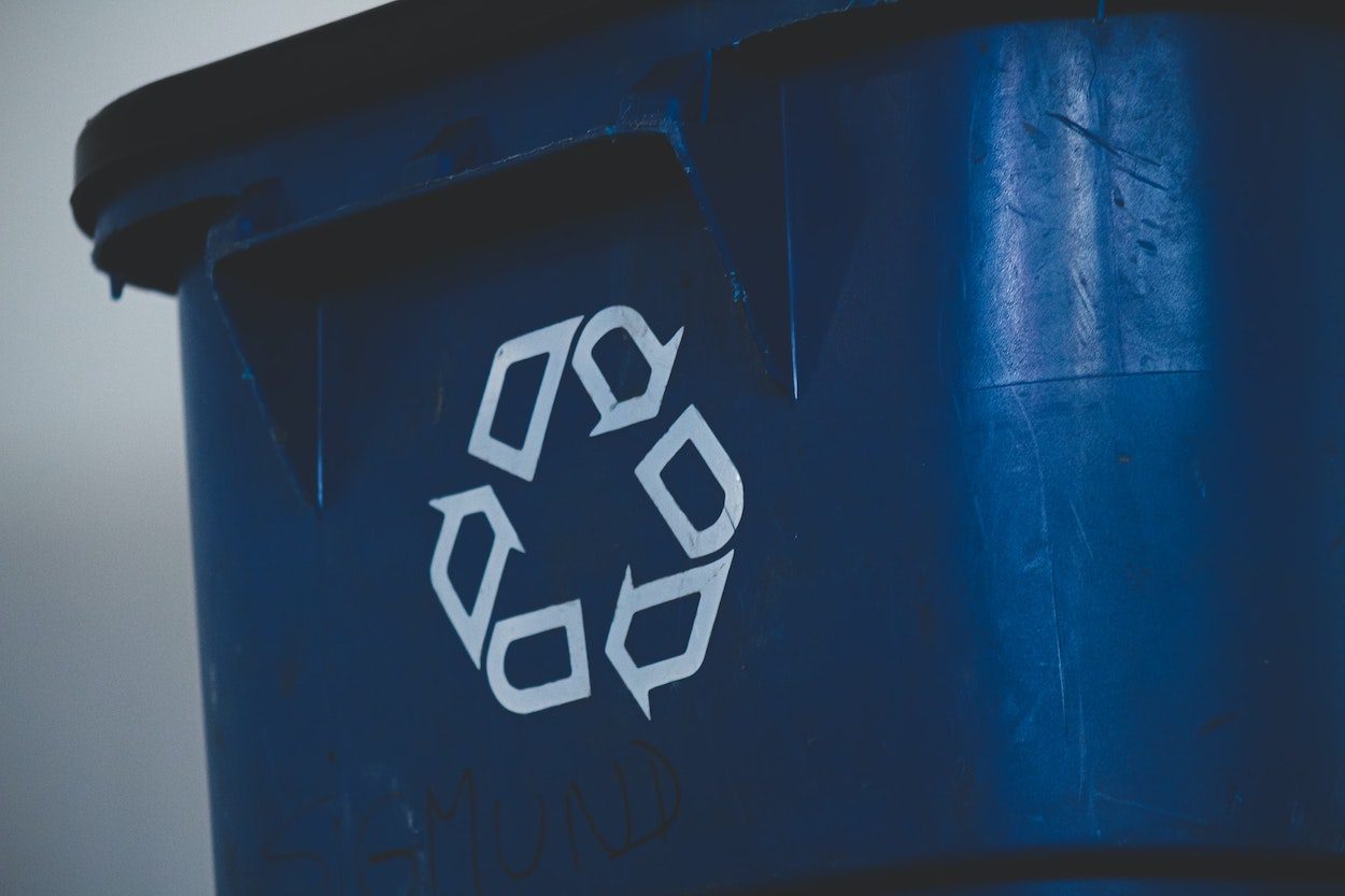 An image of a blue recycling bin with the recycling symbol on its side.
