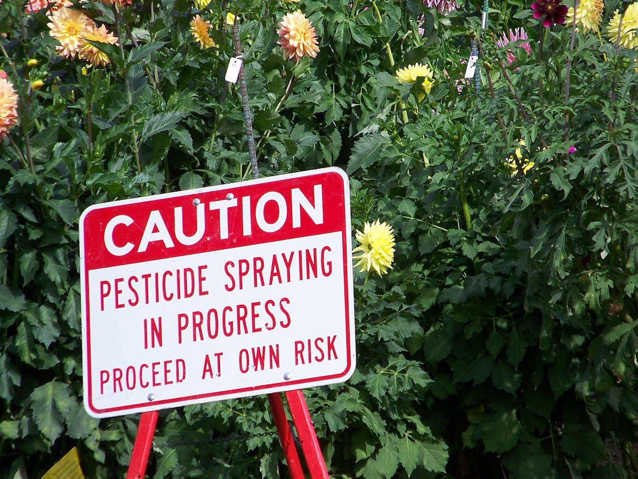 Caution sign warns of pesticide use in the area