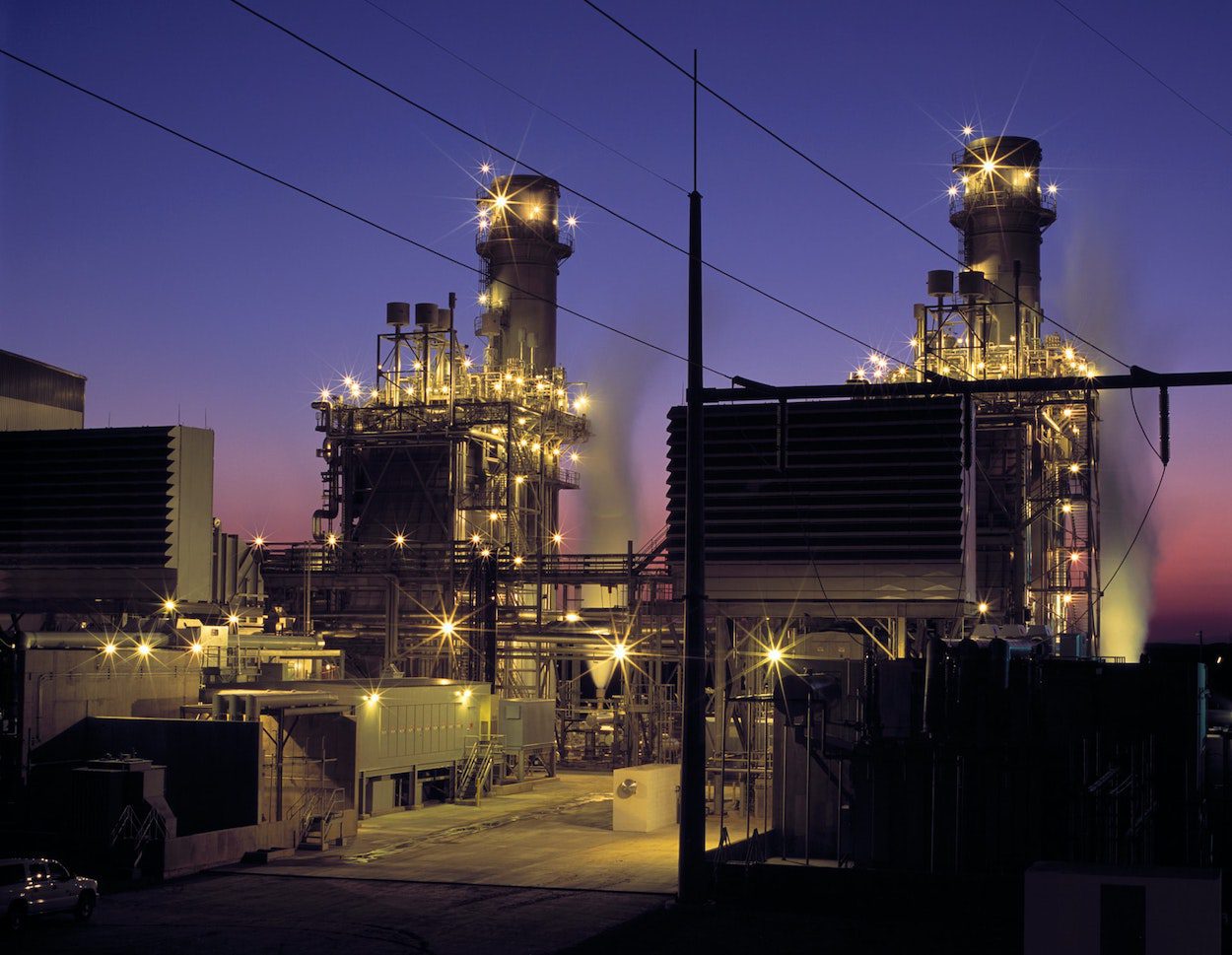 A power plant lit against an evening sky.