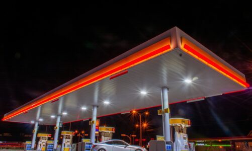 A single car refuels at a multi-pump gas station