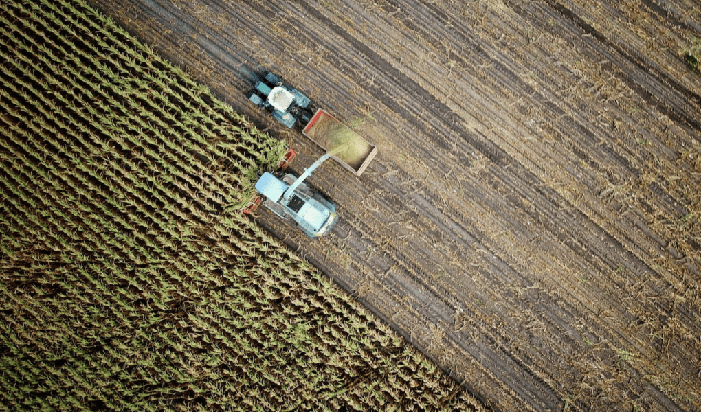 An aerial perspective of farm machine harvesting a field