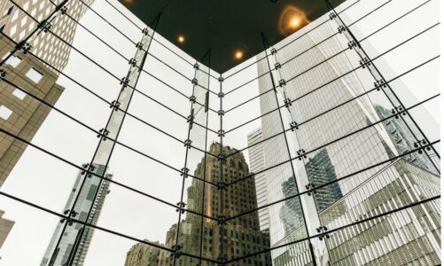Surrounding skyscrapers reflect in the glass of a towering building
