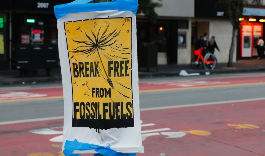 A placard posted in a street saying "break free from fossil fuels."